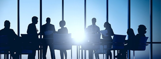 Businessmen and women having a meeting in front of a large window